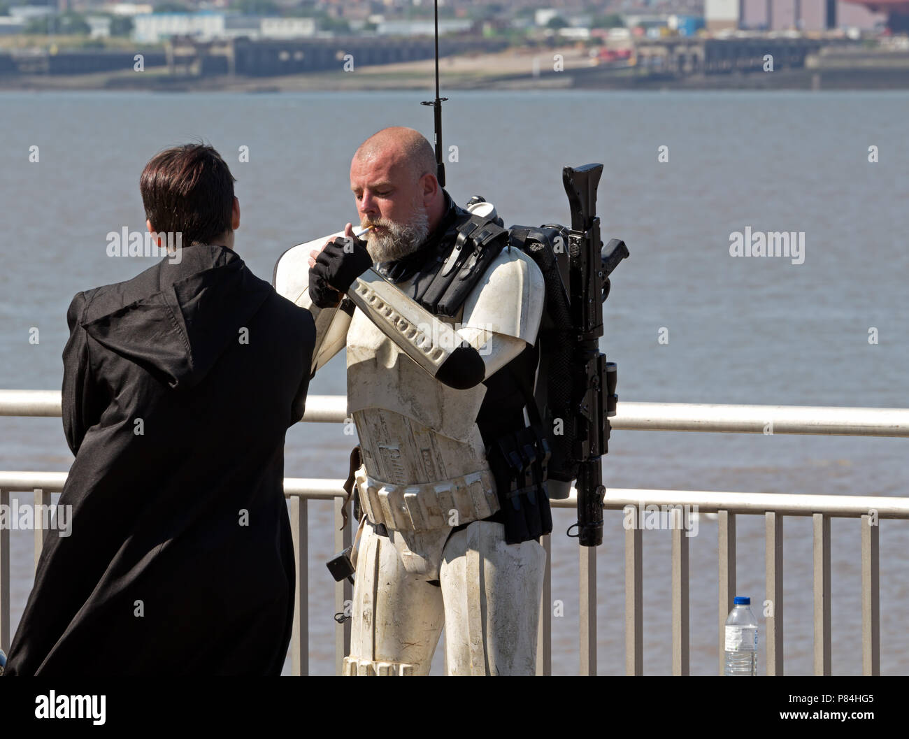 star wars cigarette A man in a Storm Trooper costume takes time out for a cigarette whilst  attending a Star Wars gathering on Liverpool Waterfront Stock Photo