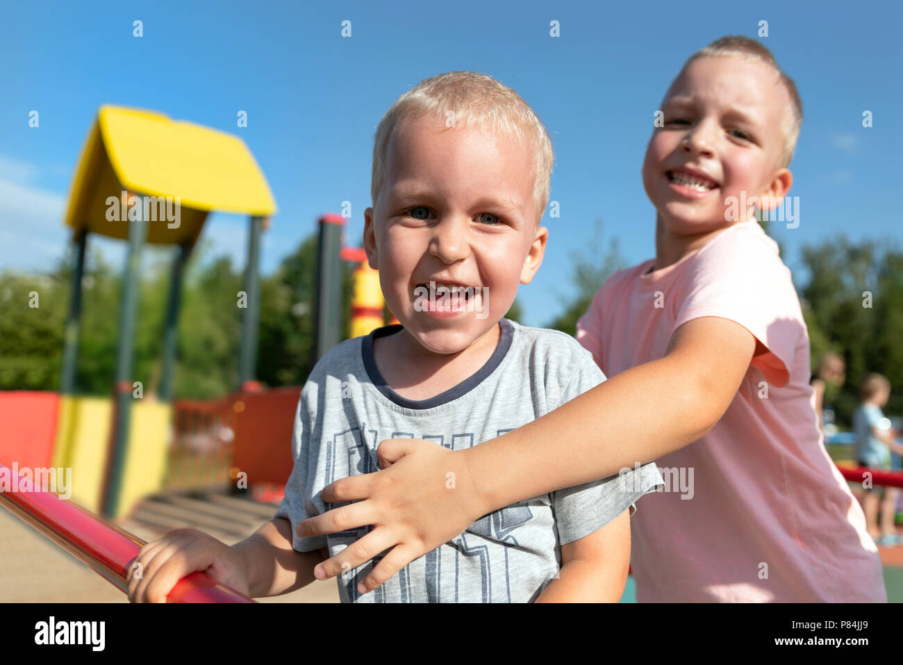 Two little boys playing together and having fun. Lifestyle family moment of siblings on playground. Stock Photo