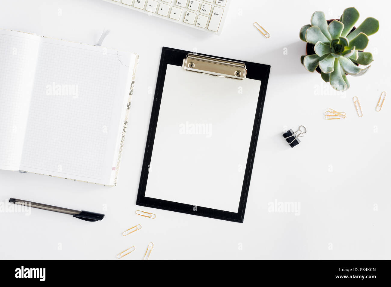Feminine desk workspace with succulent, clipboard, diary, keyboard