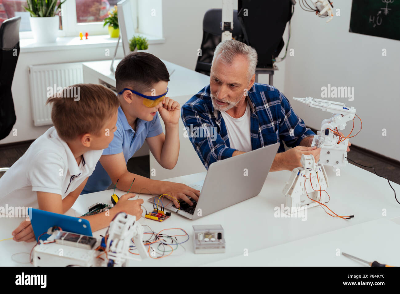 Cheerful smart boys talking to their teacher Stock Photo