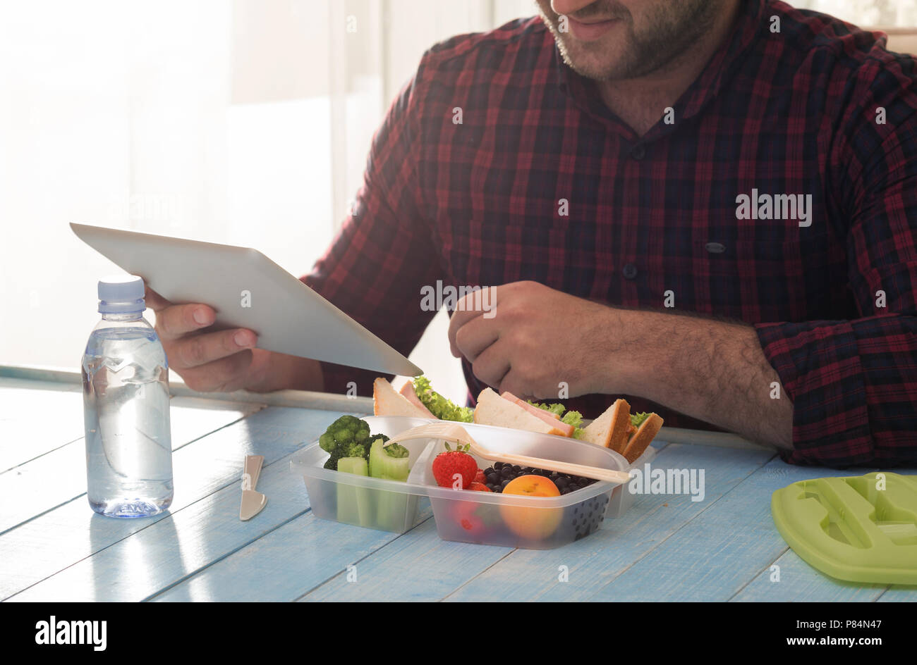 Man has a healthy breakfast in his home office. Concept of healthy