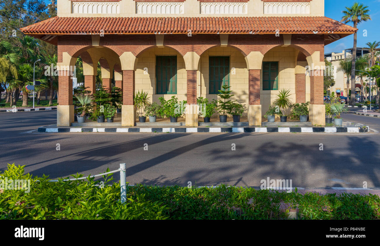 Facade of the clock tower in Montaza public park with arches, green