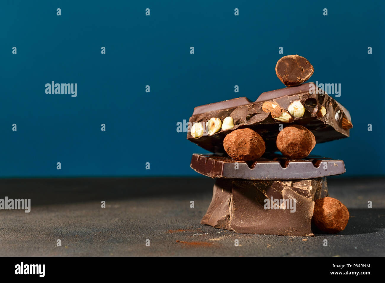 Close up dark chocolate stack on a blue background Stock Photo - Alamy