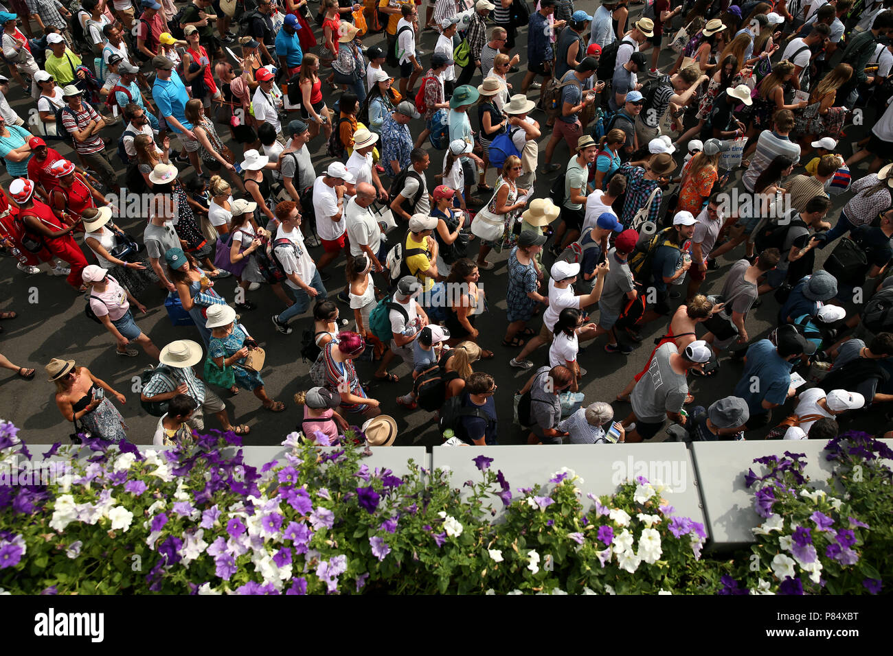 Spectators are led into the grounds at the start of day seven of the Wimbledon Championships at the All England Lawn Tennis and Croquet Club, Wimbledon. Stock Photo