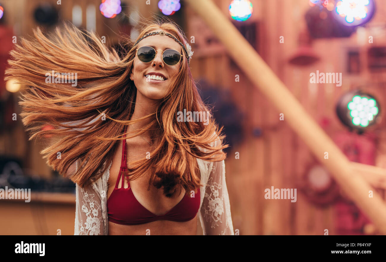 Attractive hippie woman at music festival outdoors. Caucasian woman in retro style outfit at music festival. Stock Photo