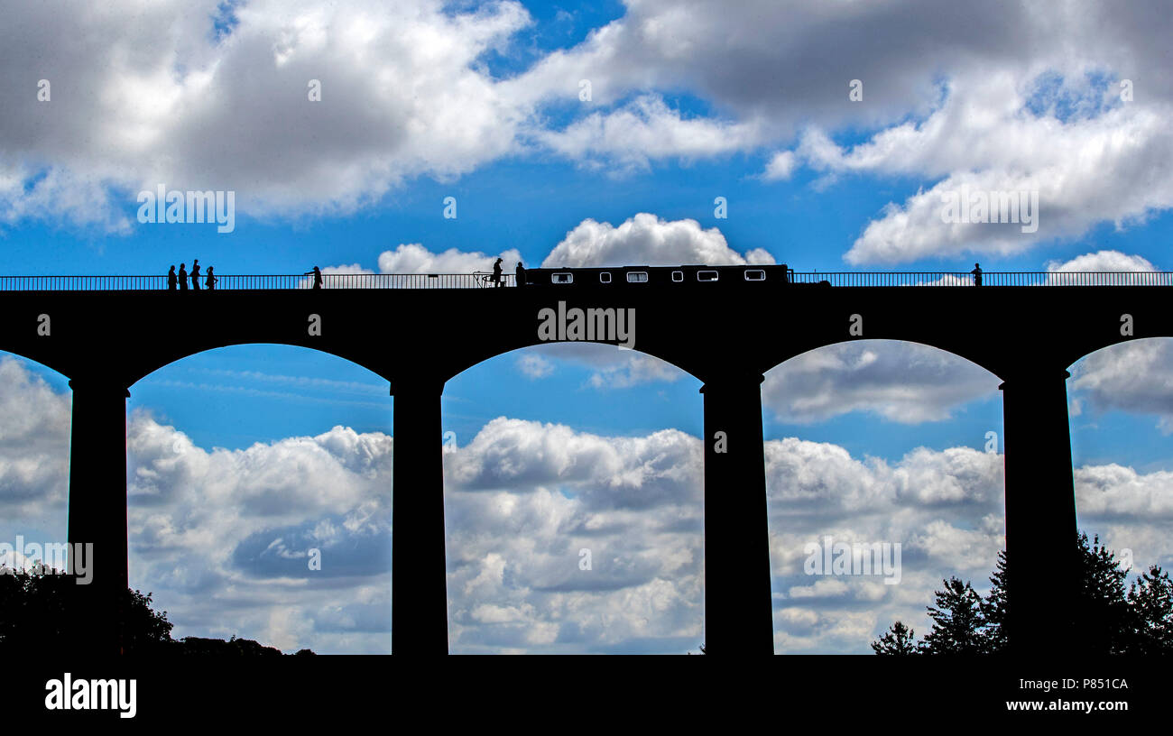 People cross the Froncysyllte Aqueduct over the Trevor Basin, Wrexham, as the warm weather continues across the country. Stock Photo