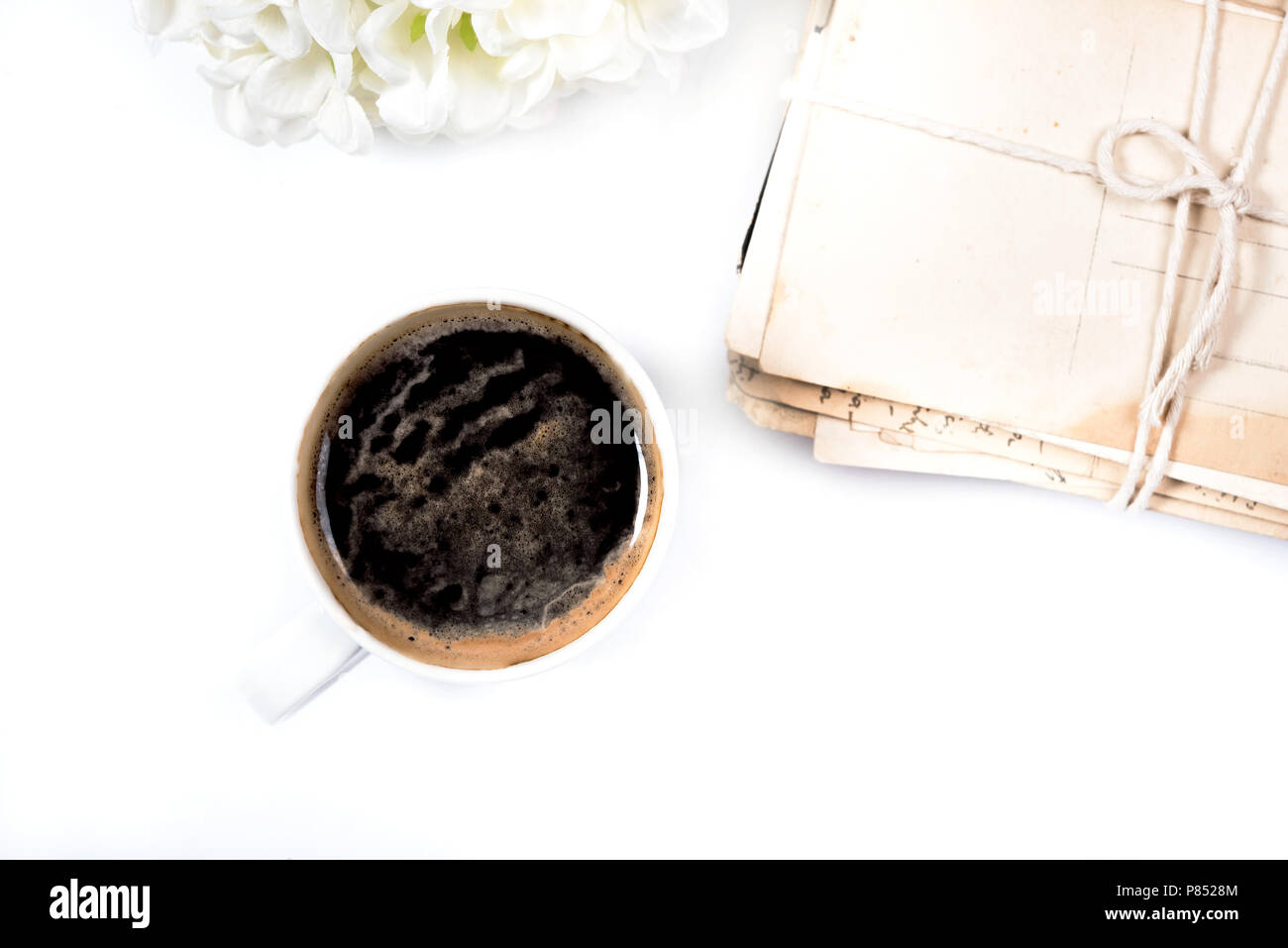 White coffee mug placed near postal cards Stock Photo