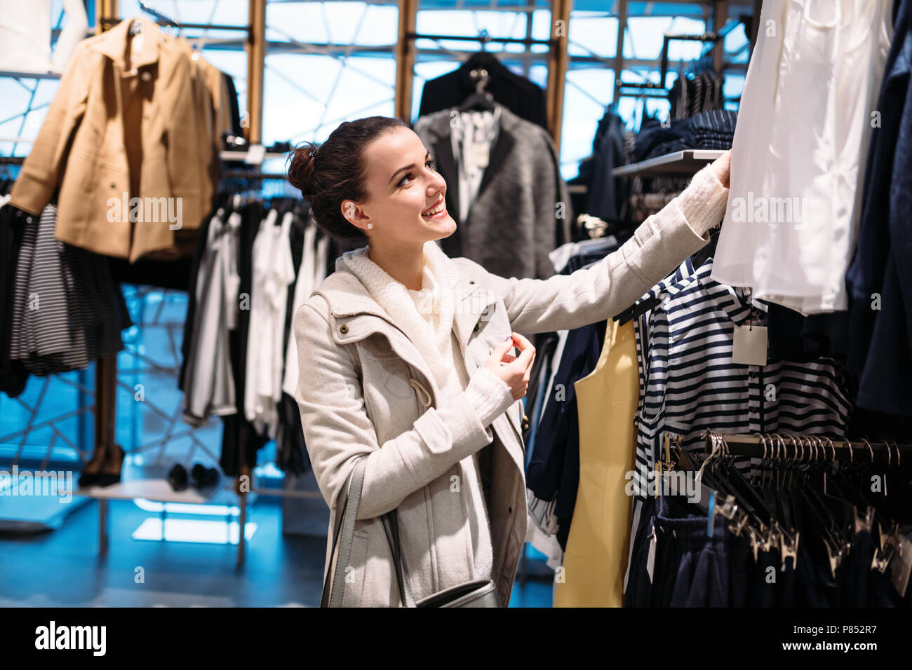 Young attractive woman buying clothes in mall Stock Photo