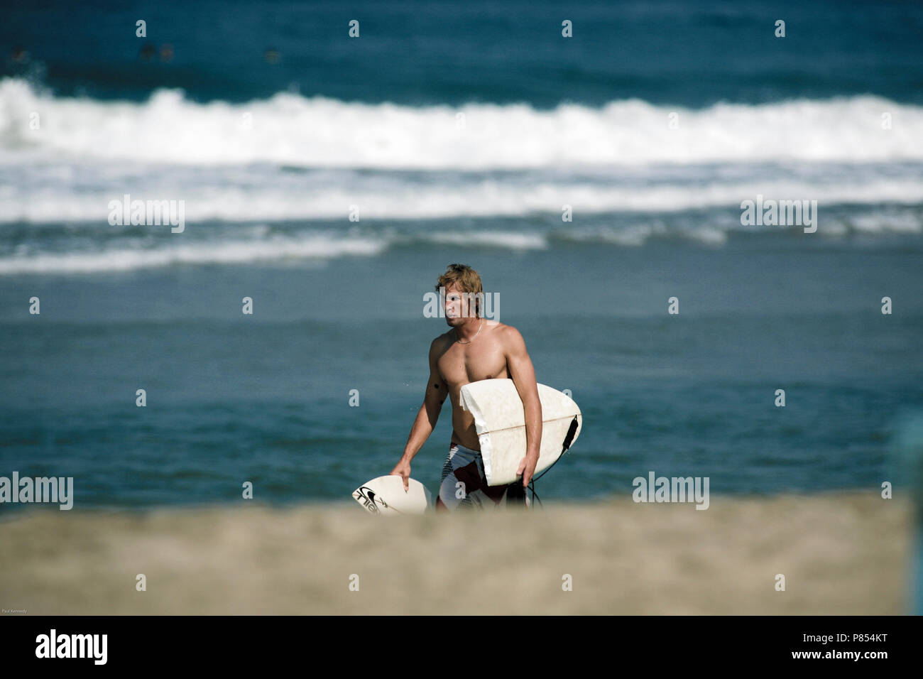 Surfer with snapped surfboard after surfing Puerto Escondido, Mexico Stock Photo