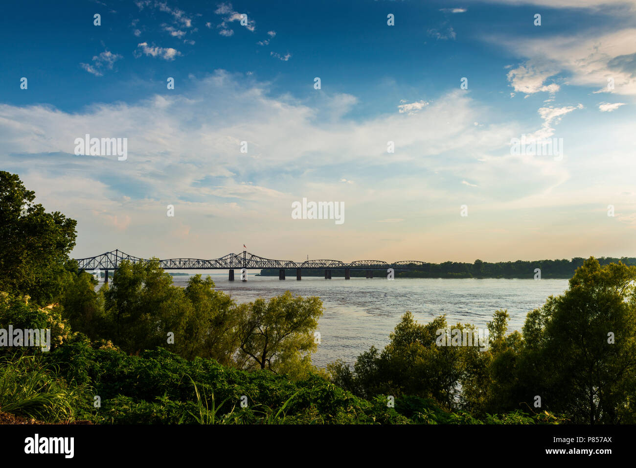View of the Mississippi River with the Vicksburg Bridge on the background at sunset; Concept for travel in the USA and visit Mississippi Stock Photo