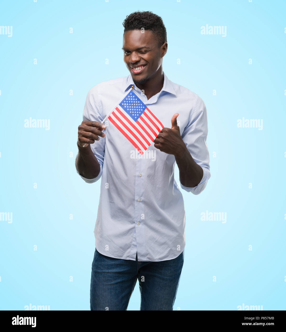 Young african american man holding USA flag happy with big smile doing ...