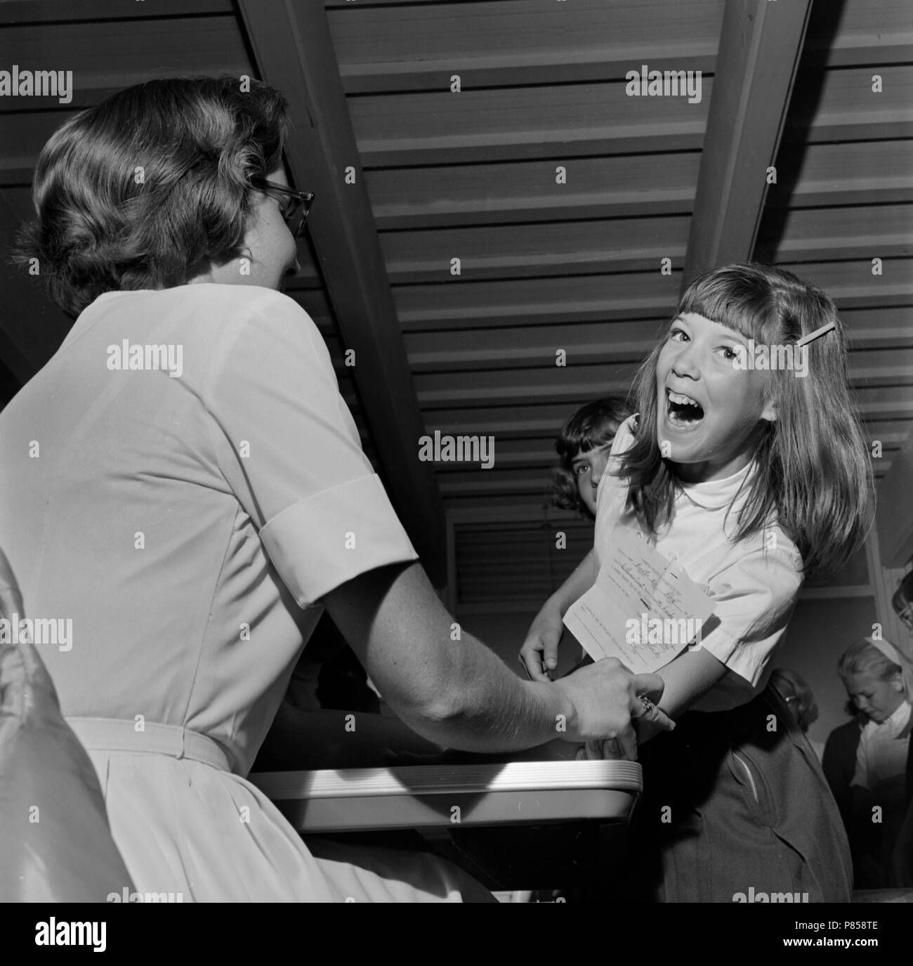 An eleven year old girl reacts as she is tested for TB in California, ca. 1965. Stock Photo