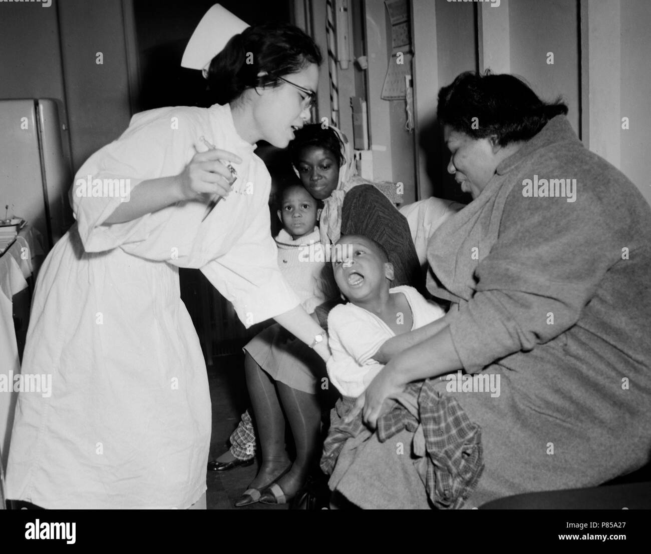 A nurse attempts to give a young child a flu shot in Chicago, ca.1962. Stock Photo