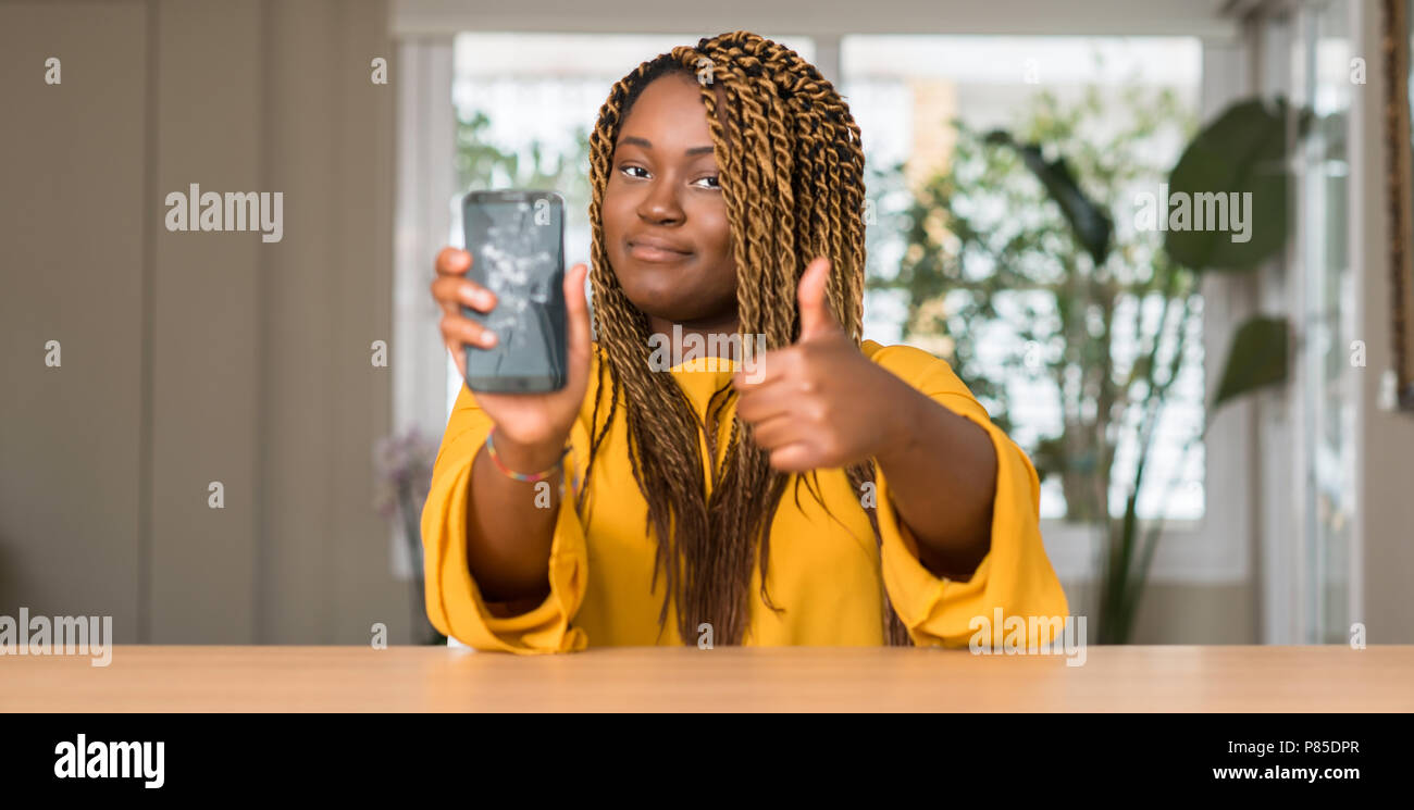 African american woman showing broken smartphone happy with big smile ...