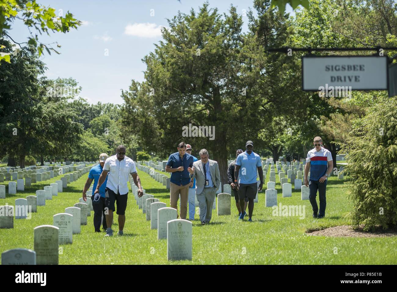 Rod Gainer (center), historian, Arlington National Cemetery, leads a tour with members of the Detroit Lions next to the Mast of the Maine in Section 23 of Arlington National Cemetery, Arlington, Virginia, June 12, 2018, June 12, 2018. The Lions visited Arlington National Cemetery to participate in an educational staff ride where they spoke with cemetery representatives, field operations, received a tour of the Memorial Amphitheater Display Room from ANC historians, and watched the Changing of the Guard Ceremony at the Tomb of the Unknown Soldier. (U.S. Army photo by Elizabeth Fraser / Arlingto Stock Photo