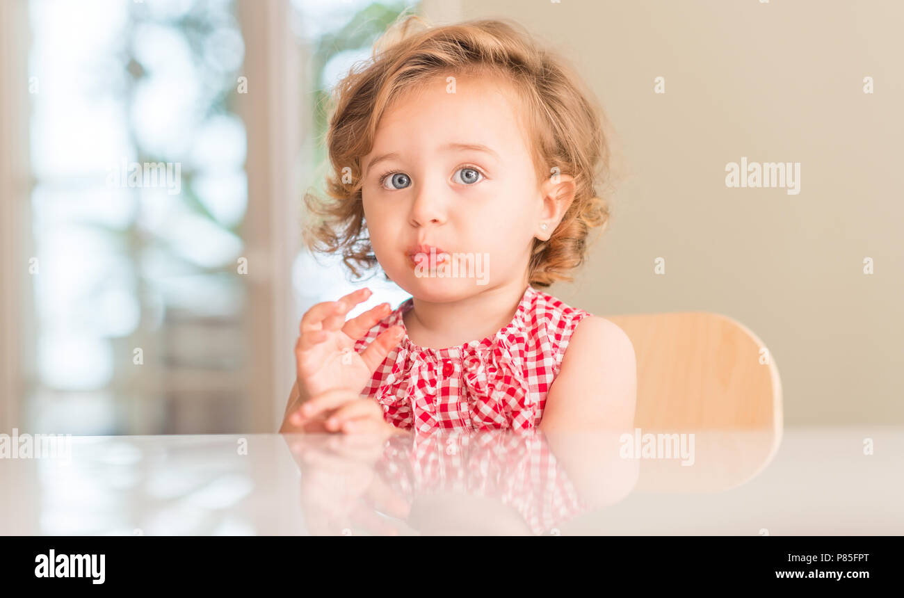 Beautiful Blonde Child With Blue Eyes Eating Strawberry At Home