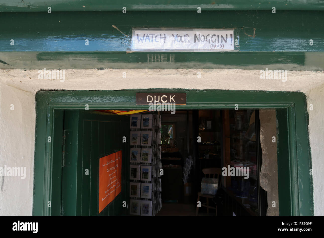 Funny sign over low doorway to duck Stock Photo