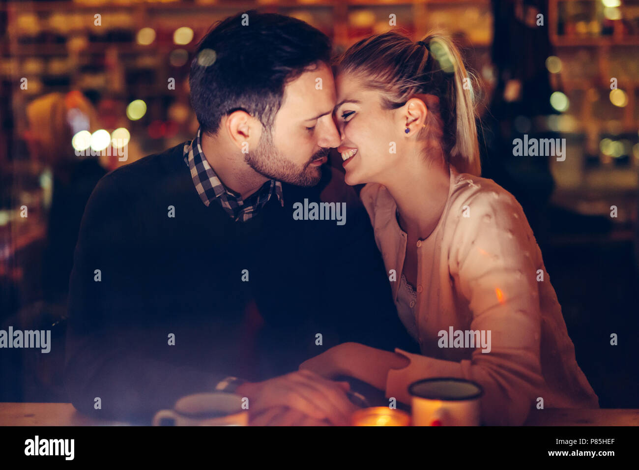 Romantic couple dating in pub at night Stock Photo