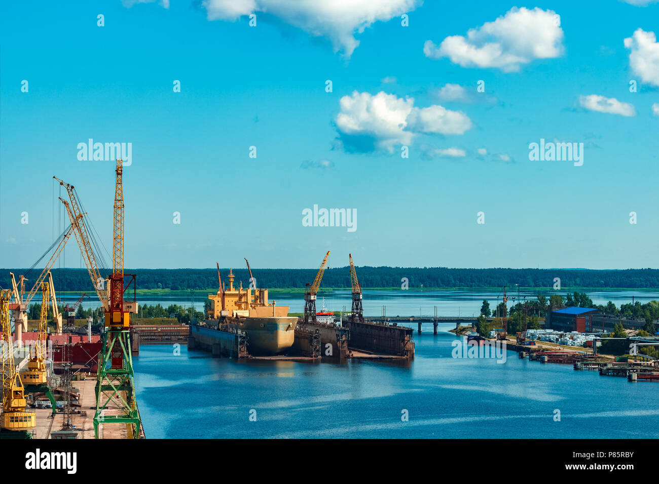 Yellow bulk carrier standing at the old shipyard in the dock Stock Photo