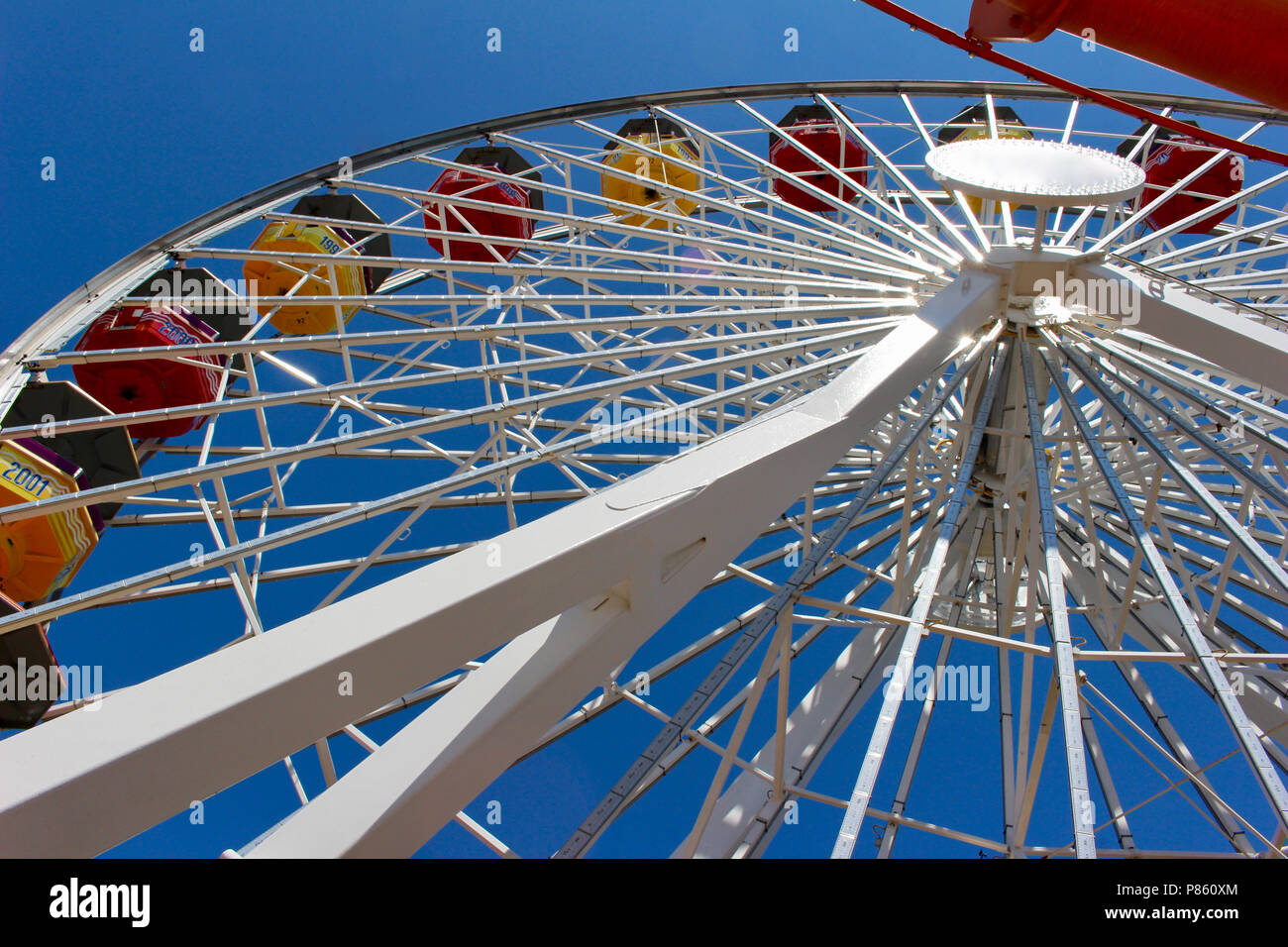 Close up view of a bright Ferris Wheel with clear blue sky background ...
