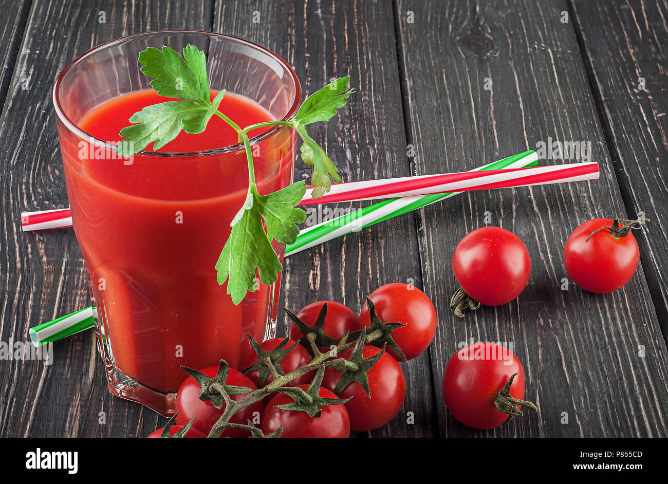 Glass of tomato juice on wooden table Stock Photo