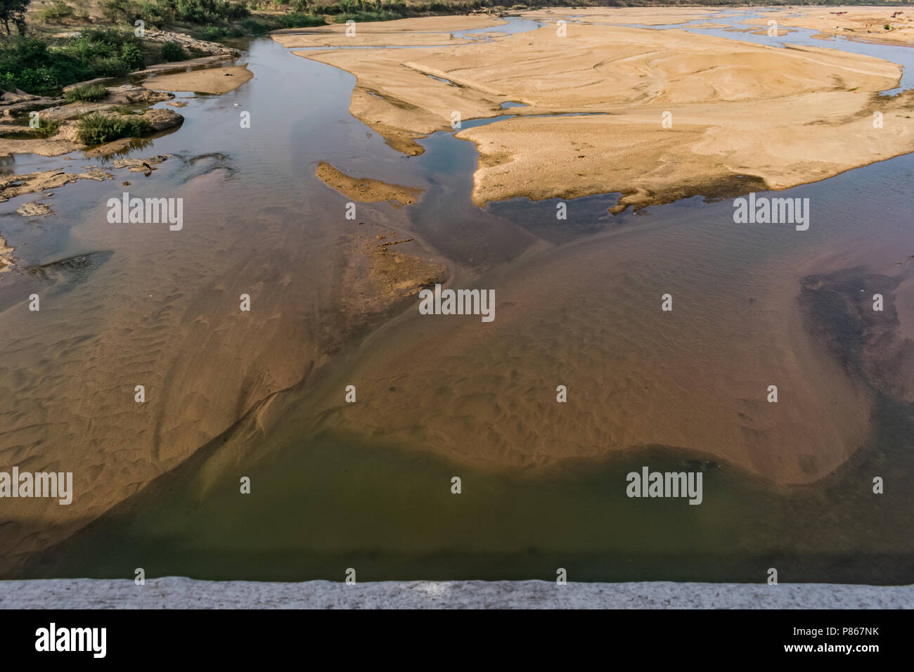 Indian river with clean water in sandy bed  with power grid cable laying background. Stock Photo