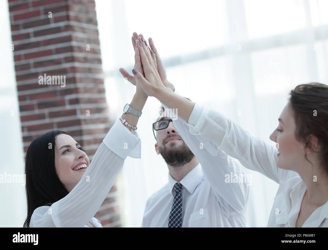 happy colleagues giving each other a high five Stock Photo - Alamy