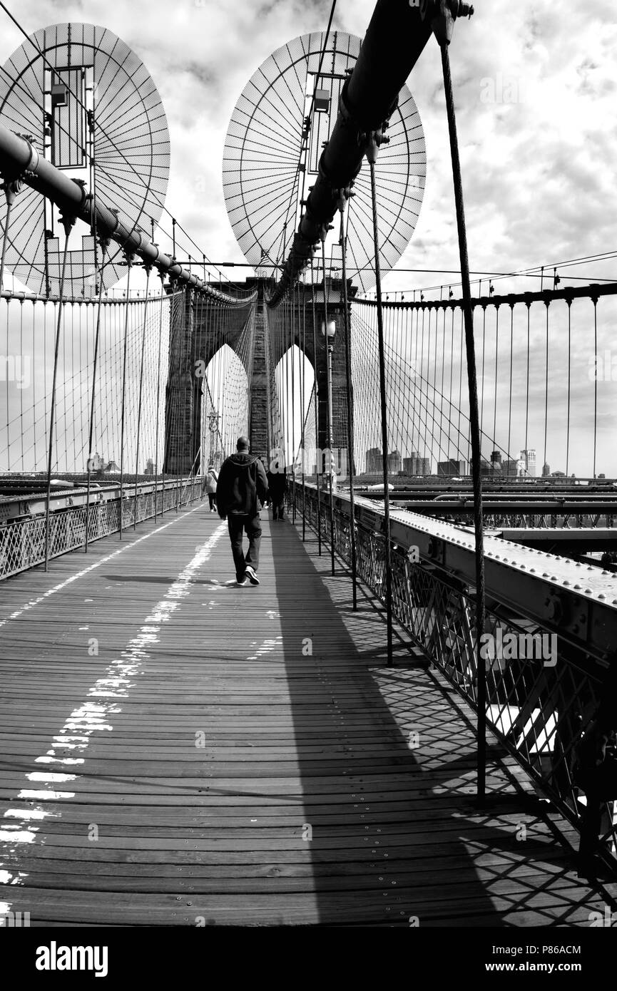 Black and white picture of the Brooklyn bridge with a leaving man Stock Photo