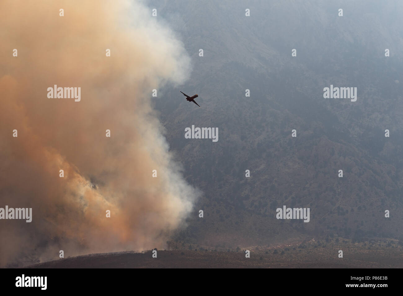 Alabama Hills, Lone Pine, CA. July 8, 2018. An air tanker after depositing fire retardant on the Georges Fire in the Alabama Hills west of Lone Pine, CA in eastern Sierra Nevadas.  The cause is under investigation. Lightning had been observed in the area. Fire crews from Inyo National Forest, the Bureau of Land Management (BLM),  CALFIRE, and local fire departments are fighting the fire with assistance from air tankers and helicopters. The helicopters are drawing water from the nearby California aquaduct. Credit: Ironstring/Alamy Live News Stock Photo