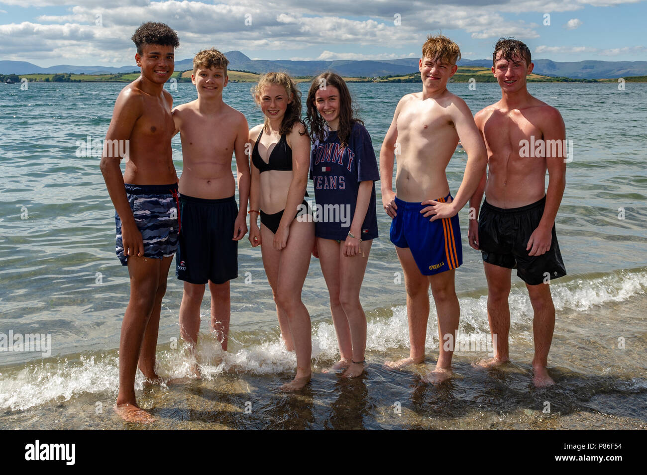Bantry, Ireland. 9th July, 2018. A group of friends enjoy the sun on Bantry beach earlier today. The heatwave is set to continue for the next week with temperatures hovering around the mid to high 20° Celsius mark. Credit: Andy Gibson/Alamy Live News. Stock Photo