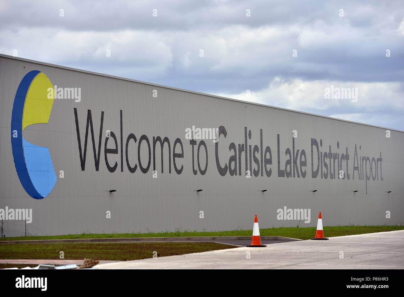 Carlisle, UK. 9th July 2018. Welcome to Carlisle Lake District Airport sign on the distribution centre wall: 9 July 2018 STUART WALKER Credit: STUART WALKER/Alamy Live News Stock Photo