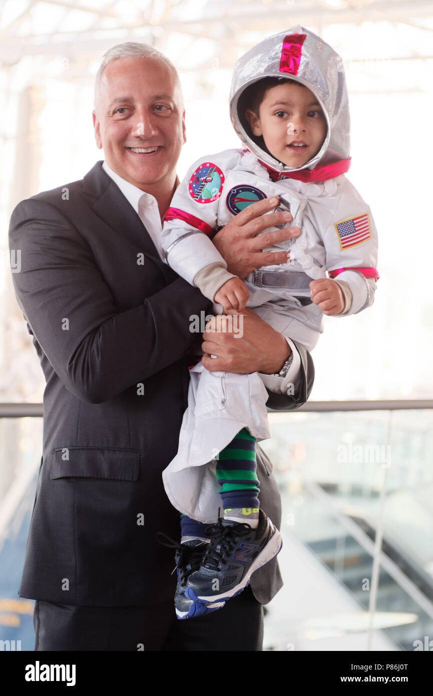 Garden City, New York, USA. 21st June, 2018. NASA space shuttle astronaut MIKE MASSIMINO poses holding GIOVANNI, a 3 1/2 year old boy wearing a space suit costume, from Manhasset, before the former astronaut gave a free lecture at the Cradle of Aviation Museum. Credit: Ann Parry/ZUMA Wire/Alamy Live News Stock Photo