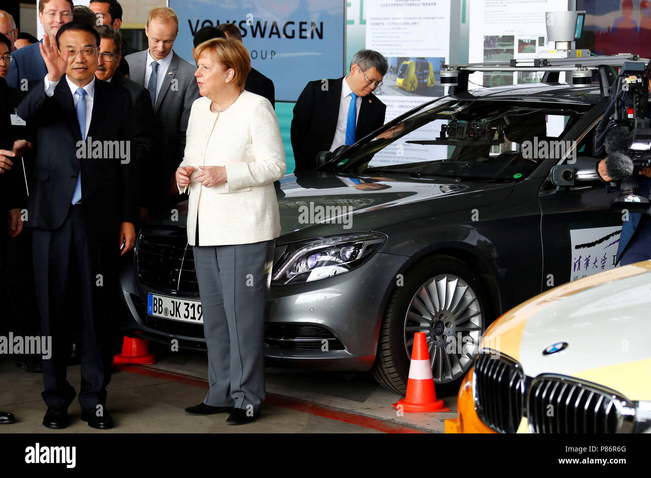 Berlin, Germany. 10th July, 2018. Chinese Premier Li Keqiang (L) and German Chancellor Angela Merkel of the Christian Democratic Union (CDU) attend a presentation for autonomous driving at Tempelhof airport in Berlin. A Mercedes Benz S-Class VRU stands next to them as a test vehicle. The visit takes place in the course of the 5th German-Chinese government consultations. Credit: Fabrizio Bensch/REUTERS POOL/dpa/Alamy Live News Stock Photo