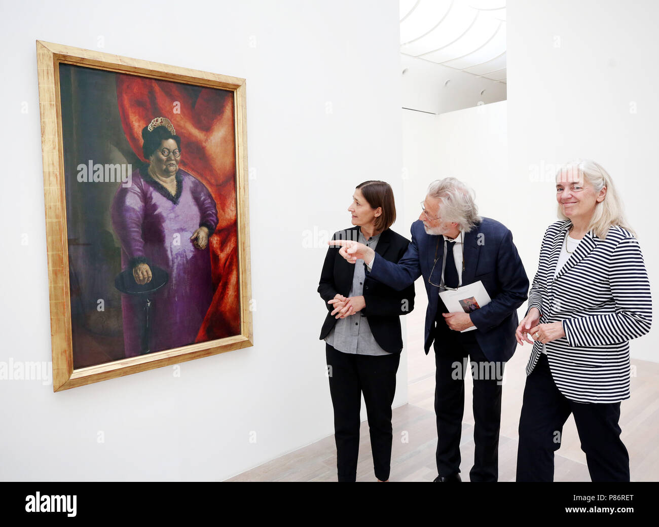 Duesseldorf, Germany. 10th July, 2018. Susanne Gaensheimer (L-R), director of the North Rhine-Westphalian art collection, Armin Zweite, art historian and Isabel Pfeiffer-Poensgen, Minister of Culture of North Rhine-Westphalia (independend) take a look at the painting 'Bildnis der Kunsthändlerin Johanna Ey' (lit. portrait of the art dealer Johanna Ey) (1924) by Otto Dix. The painting was acquired with funds of the state, the Ernst von Siemens art foundation and the culture foundation of the states. Credit: Roland Weihrauch/dpa/Alamy Live News Stock Photo