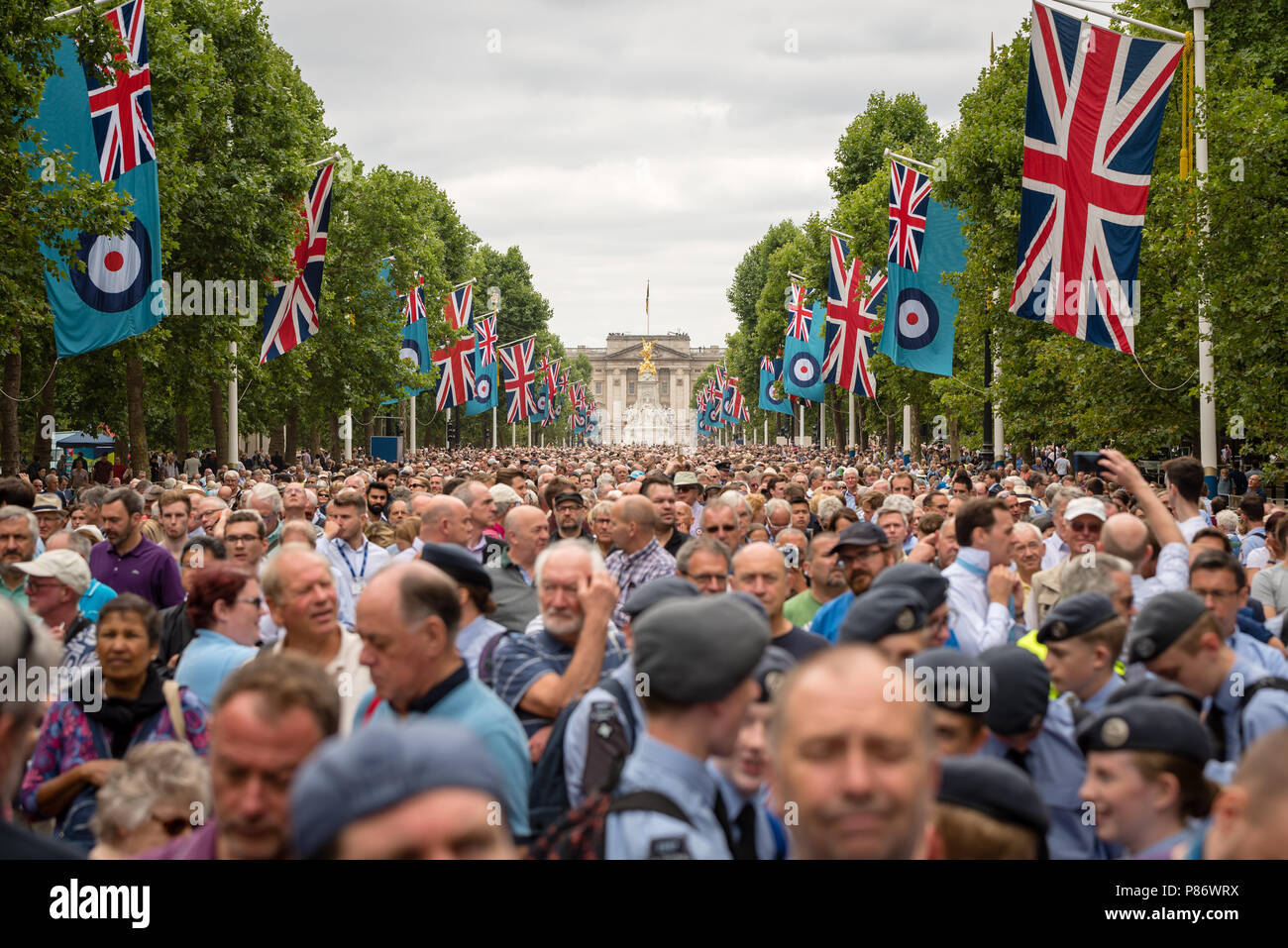 Crowds gather along The Mall to help celebrate the 100th anniversary of the Royal Air Force (RAF). The crowds watch the Royal Air Force parade followed by the flypast over Buckingham Palace in London. Stock Photo