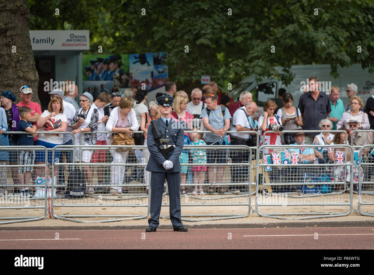 Crowds gather along The Mall to help celebrate the 100th anniversary of the Royal Air Force (RAF). The crowds watch the Royal Air Force parade followed by the flypast over Buckingham Palace in London. Stock Photo