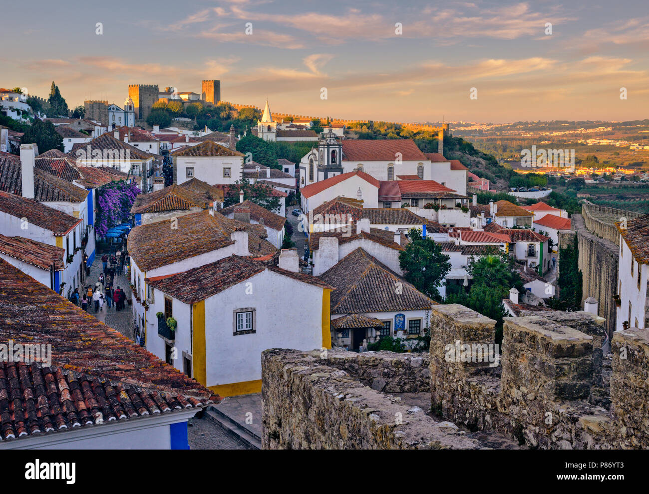 Portugal, Estremadura region, Costa da Prata, Obidos, medieval walled town, evening view of the Pousada, castle and cobbled street Stock Photo