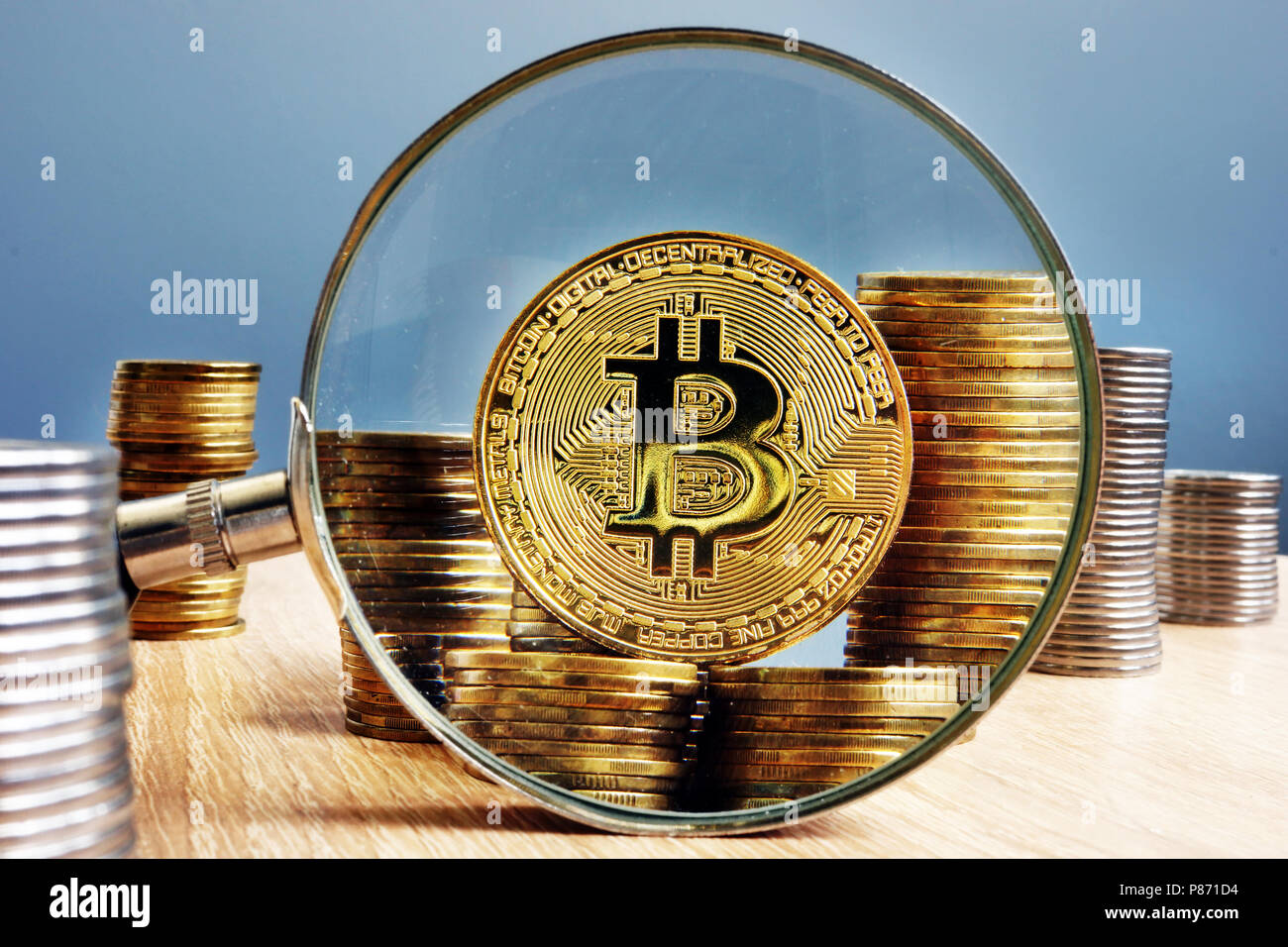 Bitcoin BTC, coins and magnifying glass. Stock Photo