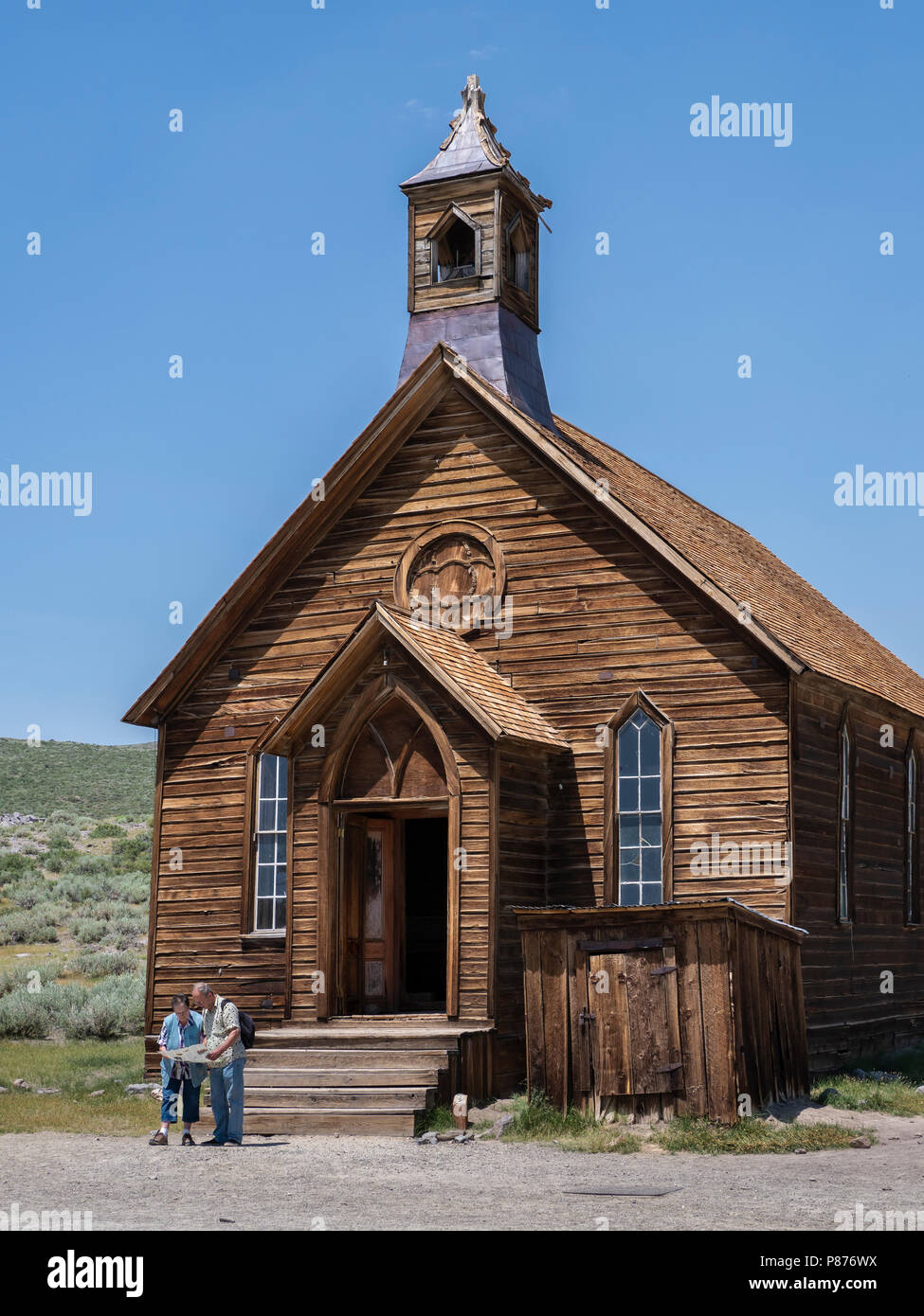 Puzzled couple check their map in front of the Methodist Church, Bodie ghost town, Bodie State Historic Park, California. Stock Photo