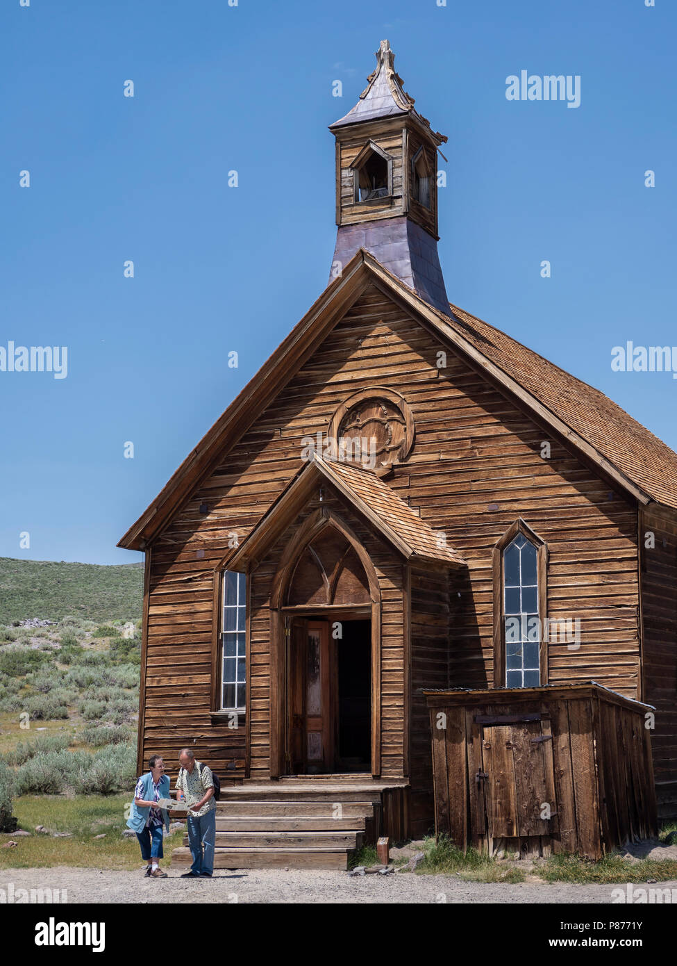 Puzzled couple check their map in front of the Methodist Church, Bodie ghost town, Bodie State Historic Park, California. Stock Photo