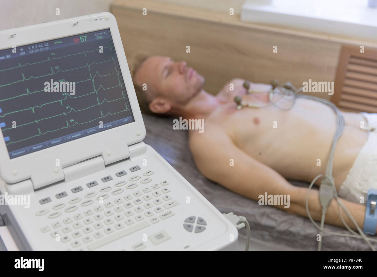 doctor with electrocardiogram equipment making cardiogram test to male patient in hospital clinic heart monitor Stock Photo
