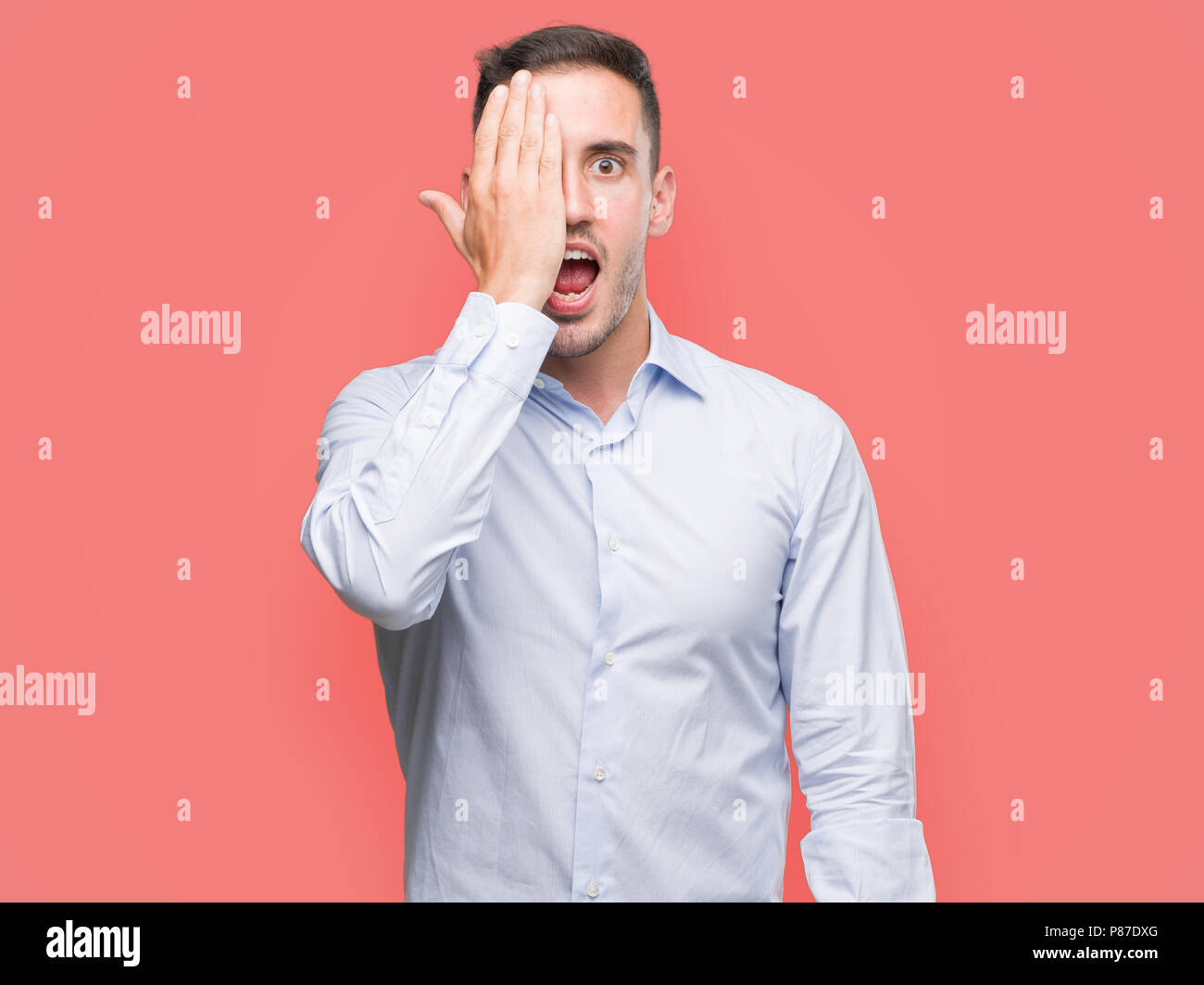 Handsome young businessman covering one eye with hand with confident ...