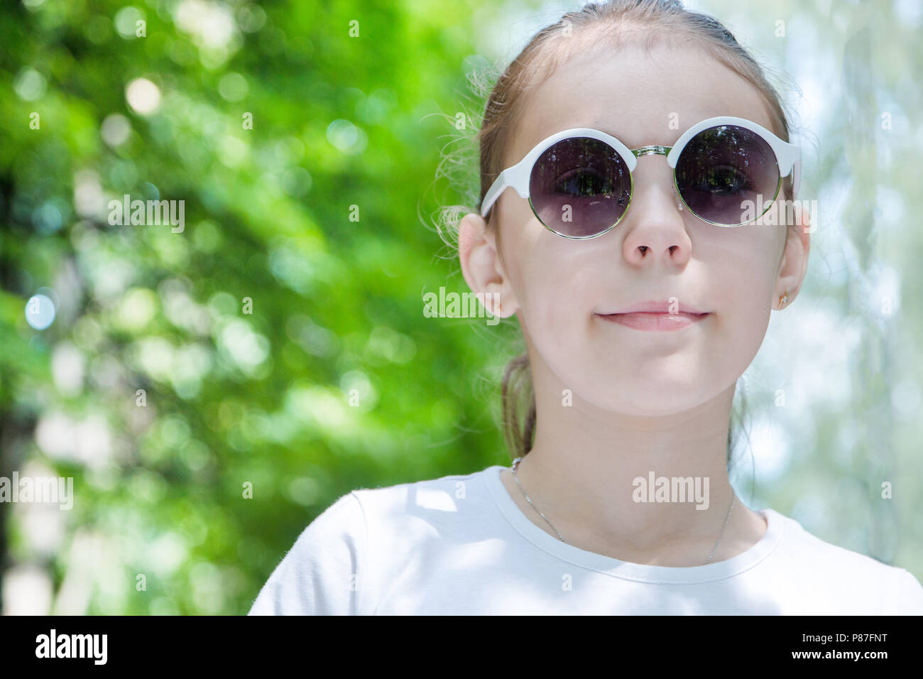 portrait of cute smiling girl in the forest in sunglasses close up ...