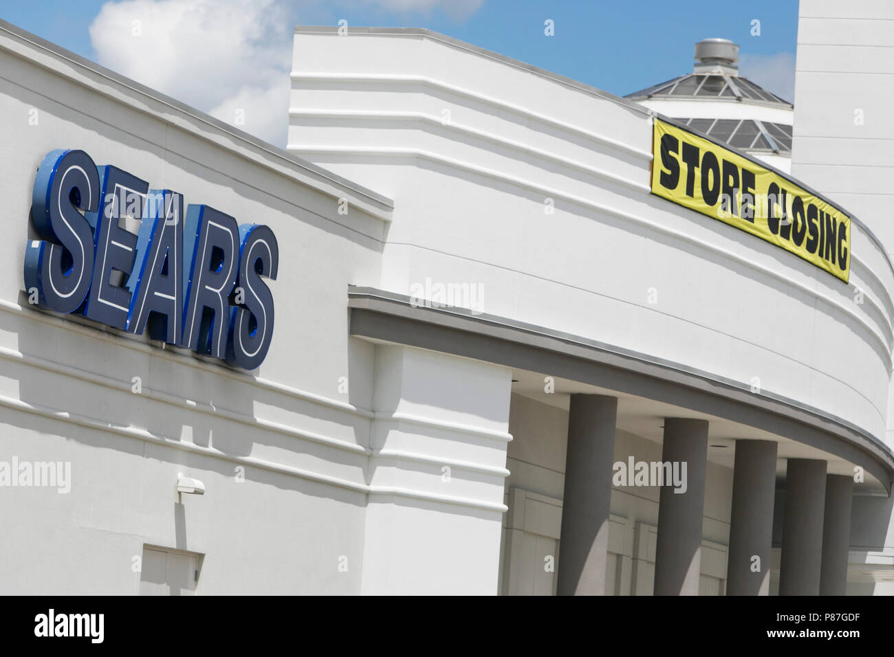 A logo sign and 'Store Closing' banner outside of a Sears retail store location in Omaha