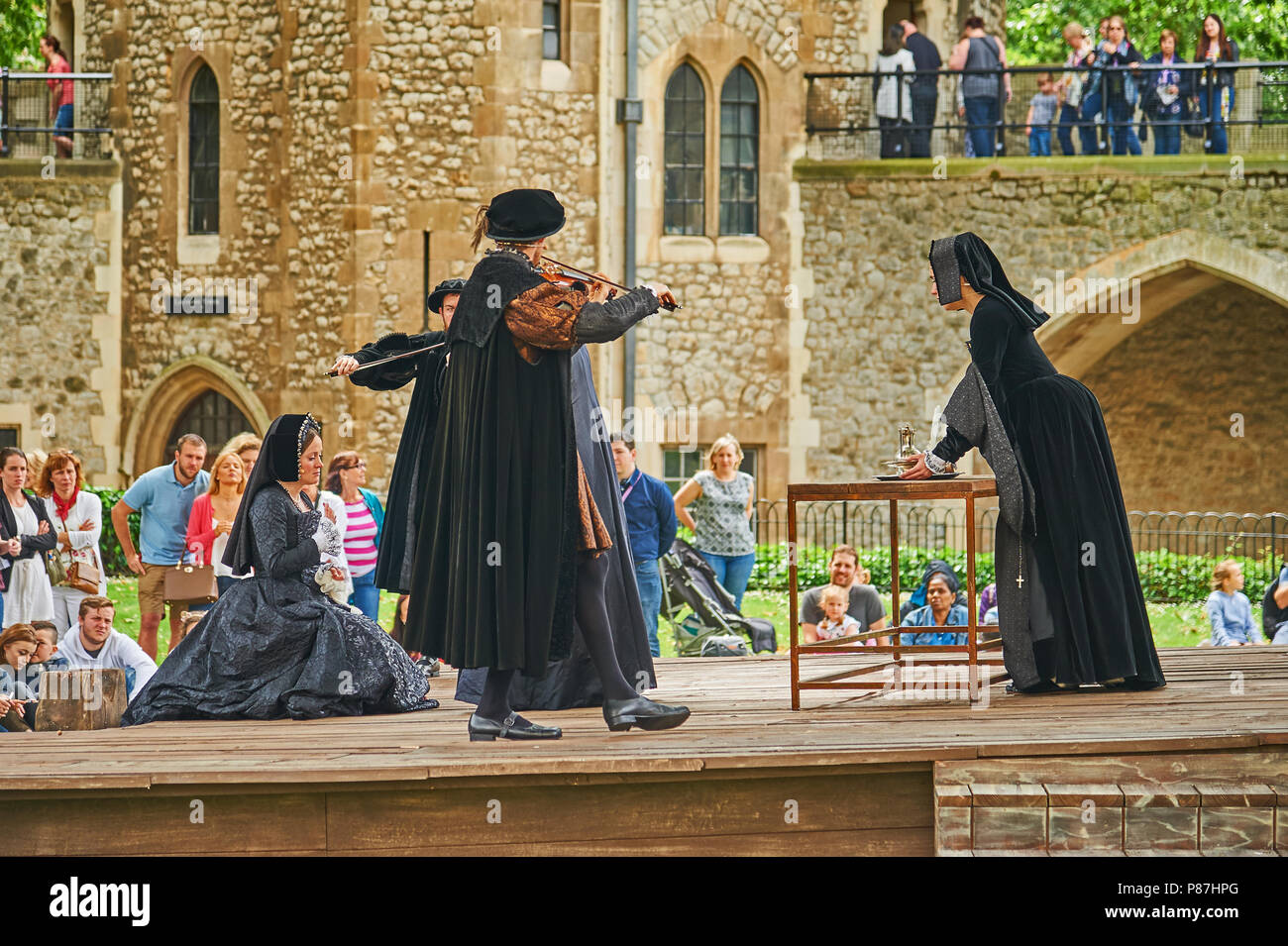Actors and actresses performing  the death of Anne Boleyn in front of tourists in the Tower of London Stock Photo