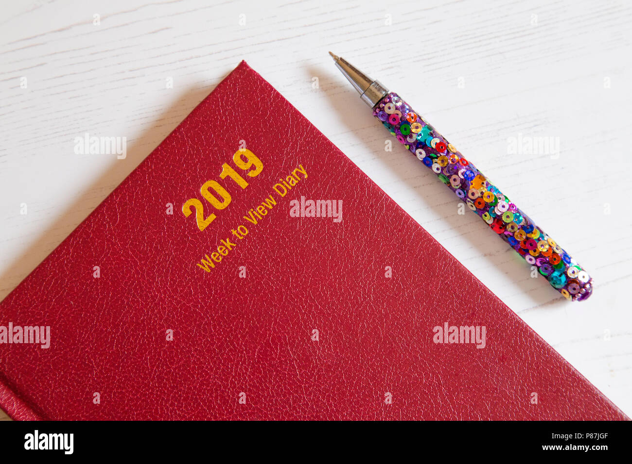 A red 2019 desk diary with a pen. Stock Photo