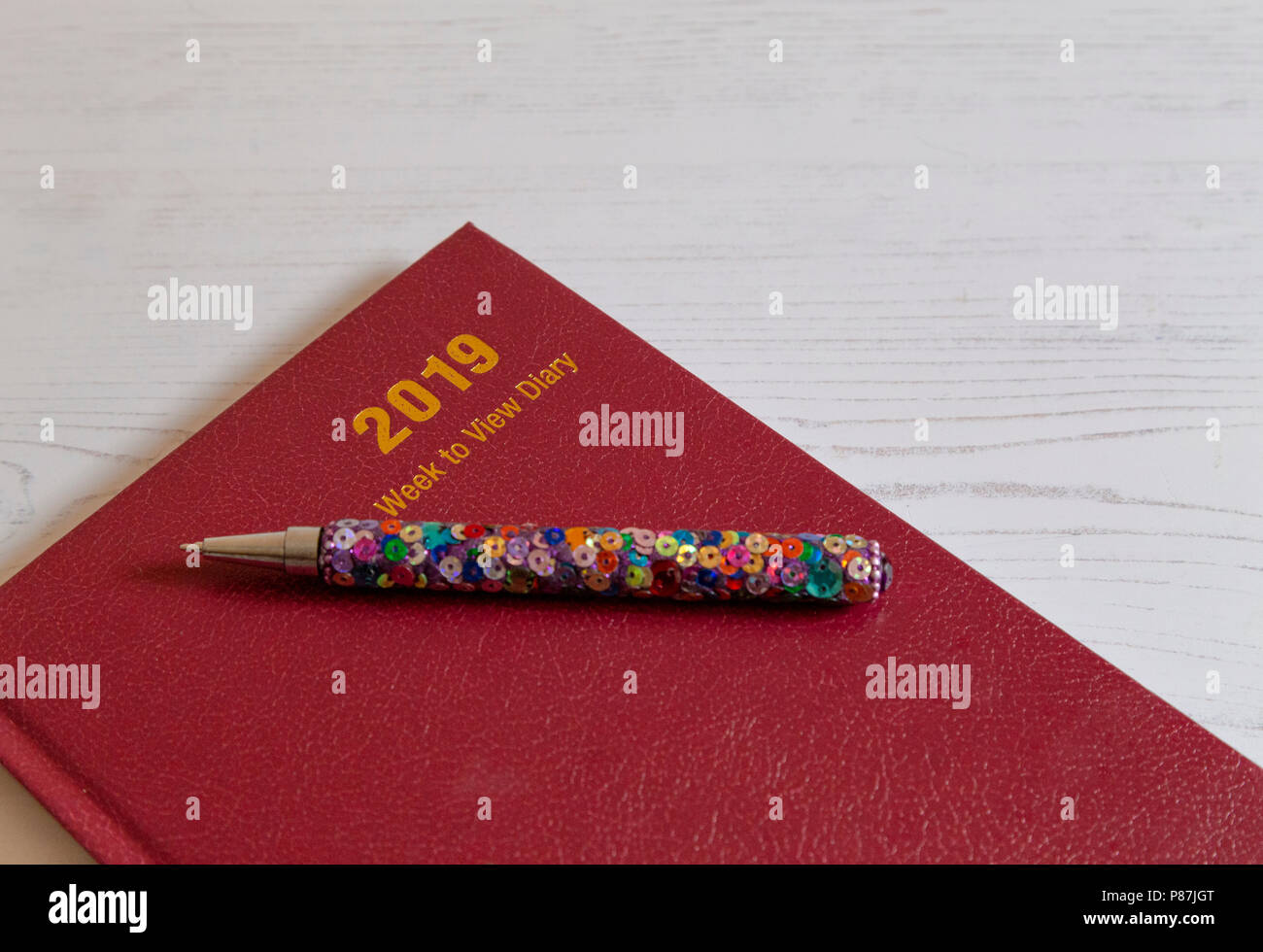 A red 2019 desk diary with a pen. Stock Photo
