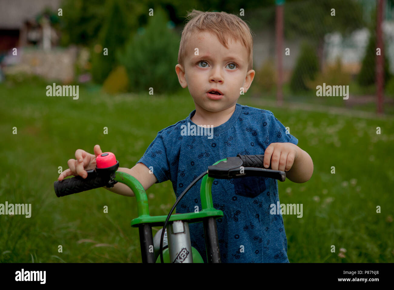 A cute little boy with a bicycle near the house, a sport for children