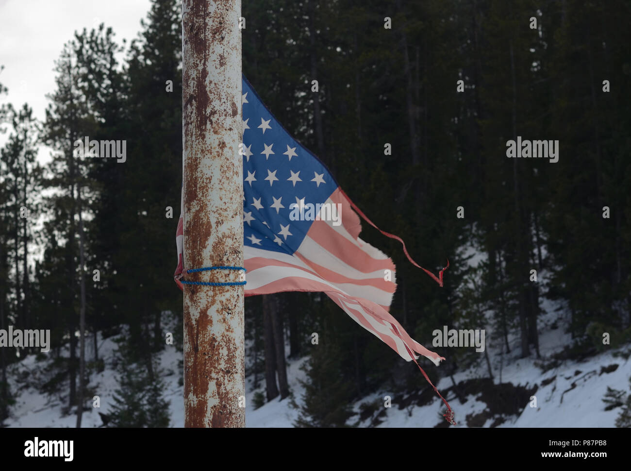 Wind and sun worn flag in Rocky Mountains Stock Photo