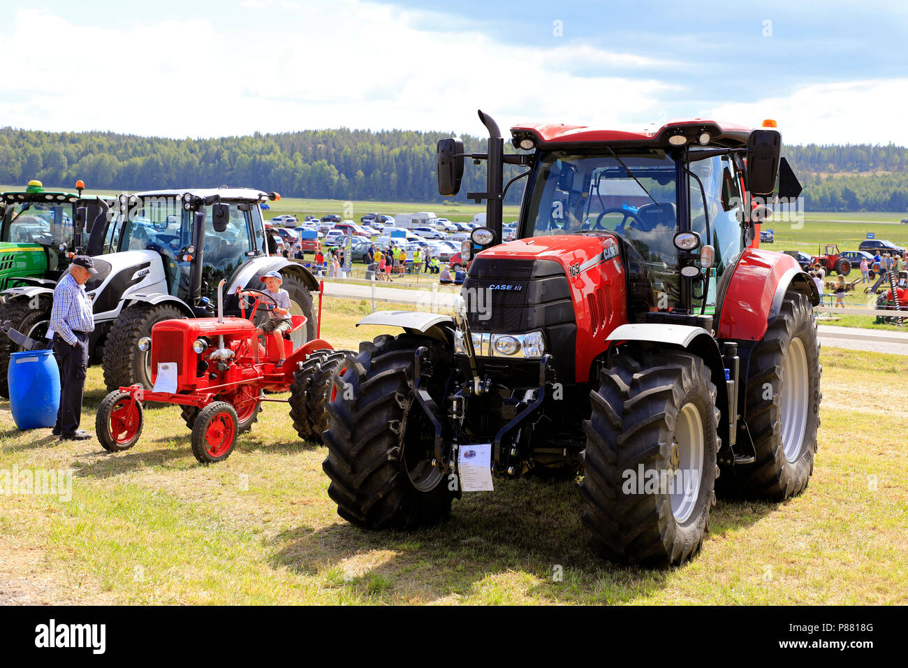 Big Case IH 165 and small Valmet 15 tractors, latter driven by young boy on Kimito Traktorkavalkad, Tractor Cavalcade. Kimito, Finland - July 7, 2018. Stock Photo